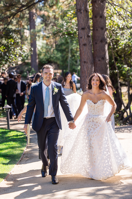Newlyweds walk together through the wooded wedding venue