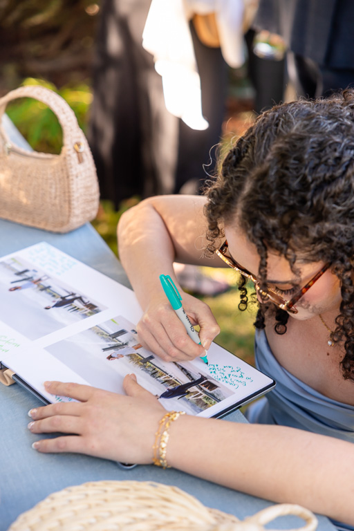 Guest writes a note in the sign-in guestbook at the reception table