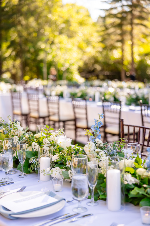 Reception table set with flowers, candles, and place settings