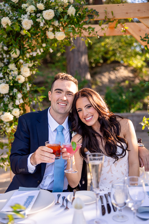 Bride and groom show off their colorful signature cocktails