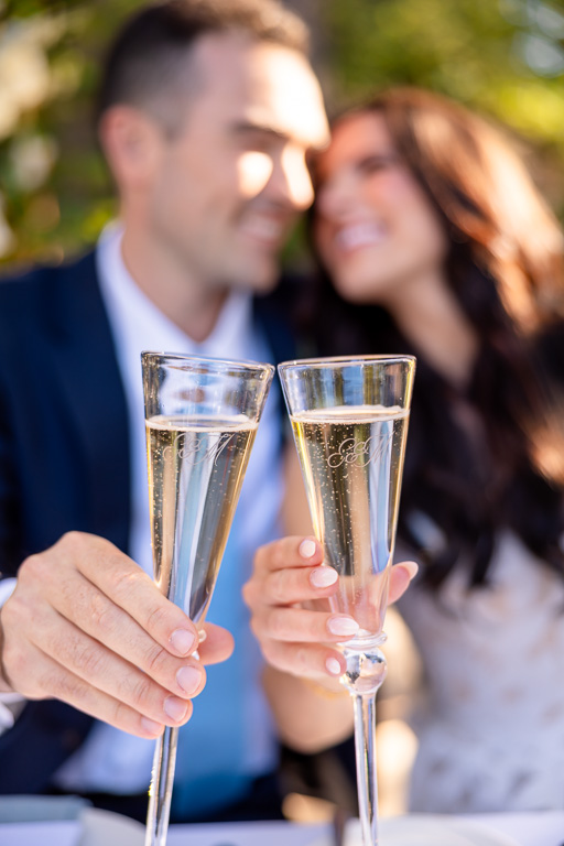custom-engraved champagne flutes meet in a close-up reception toast