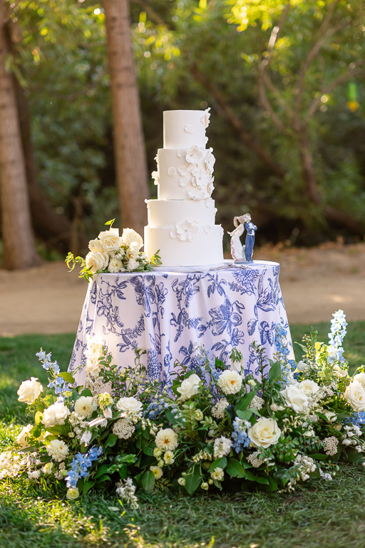 Wedding cake displayed beneath a floral arrangement