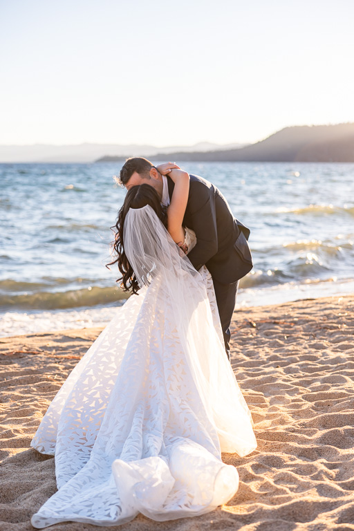 Bride and groom embrace beside Lake Tahoe at sunset