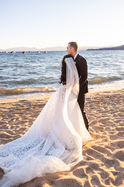 Bride’s veil trails behind the newlyweds beside Lake Tahoe