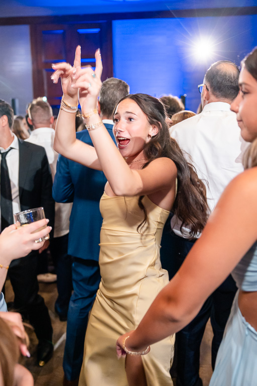 Wedding guests celebrate together beneath blue lights