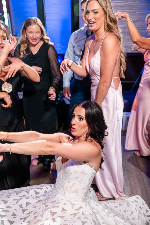 Bride dances on the floor as guests gather around her