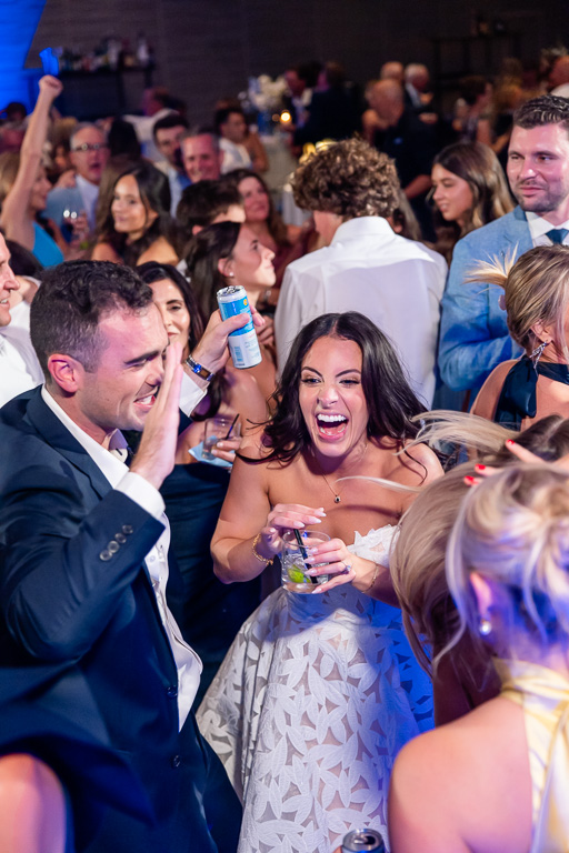 Bride and groom dance together surrounded by guests