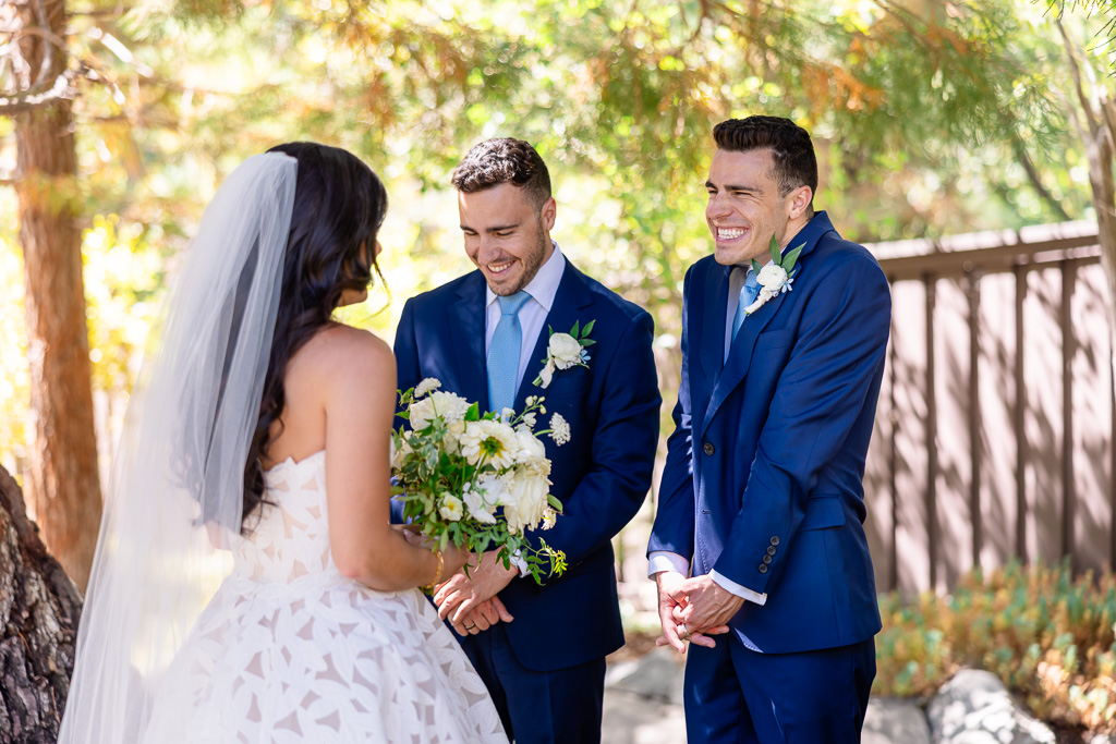 bride's first look with her two brothers under pine trees
