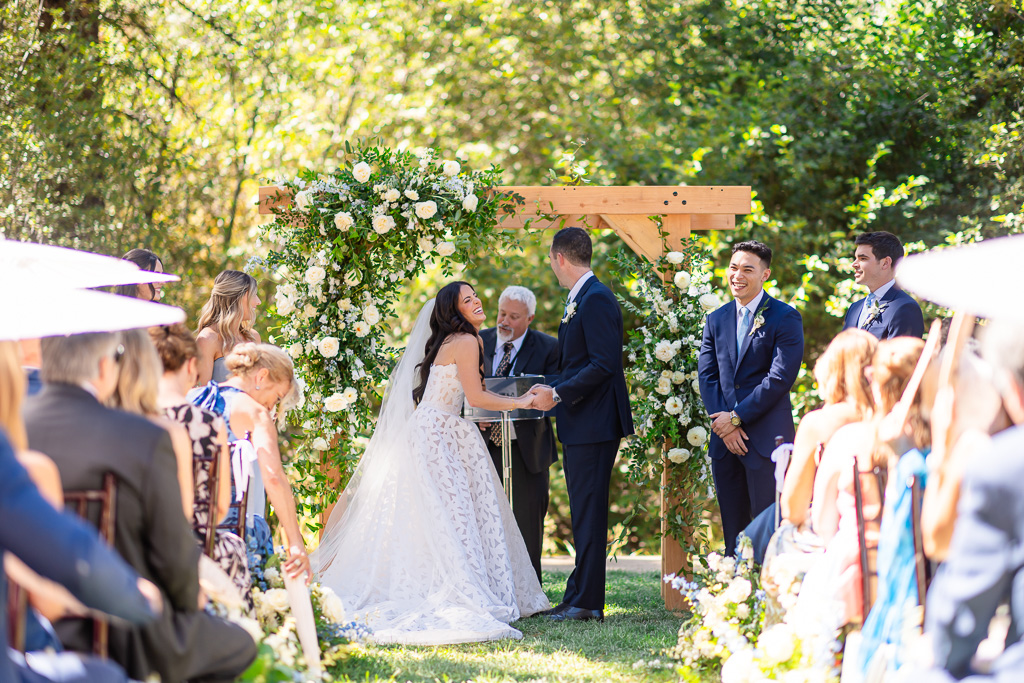 Creekside Lawn wedding ceremony framed by flowers and the surrounding forest