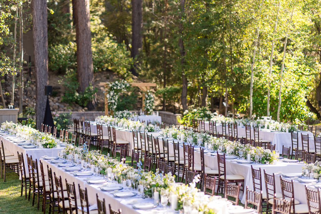 Reception tables arranged beneath the pines at Hyatt Regency Lake Tahoe Resort on the Creekside Lawn