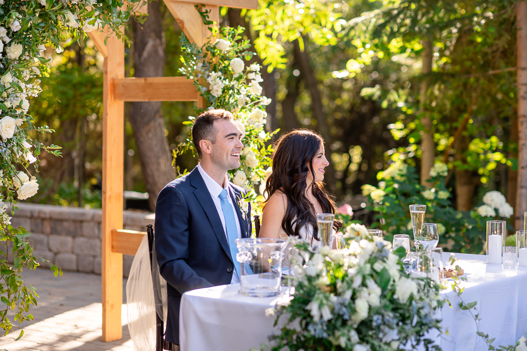 Bride and groom sit together at their sweetheart table