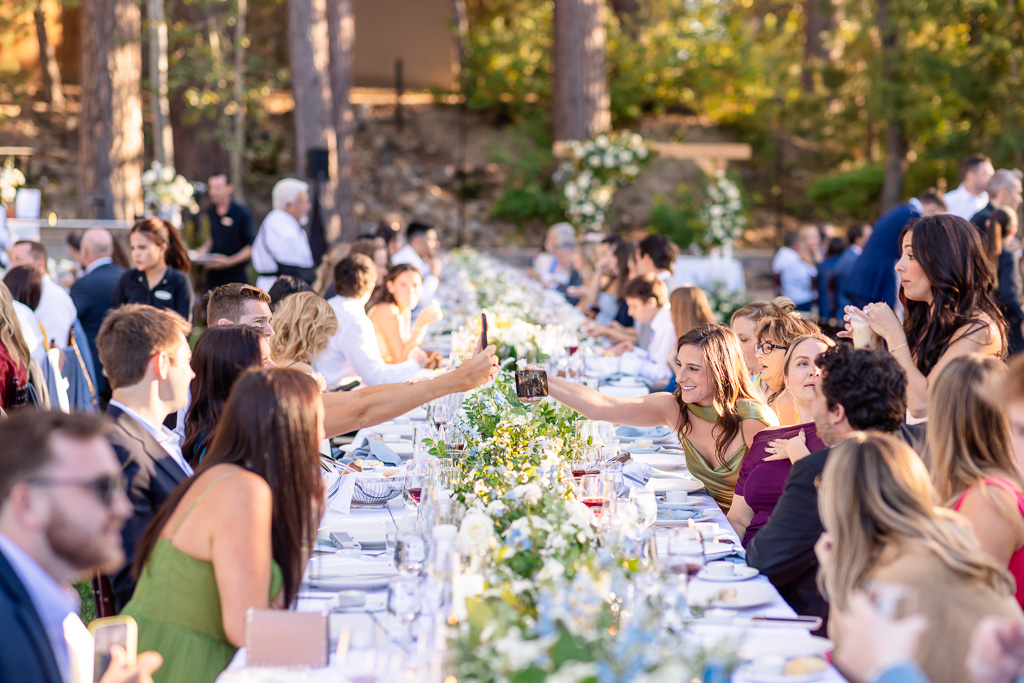 Wedding guests dine together at the outdoor reception