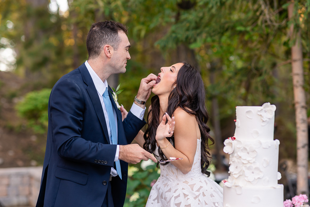 Groom feeds the bride a bite of wedding cake