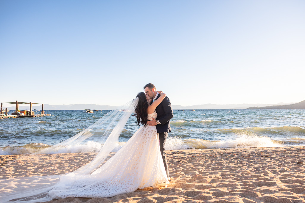 Bride and groom kiss beside the Lake Tahoe shoreline