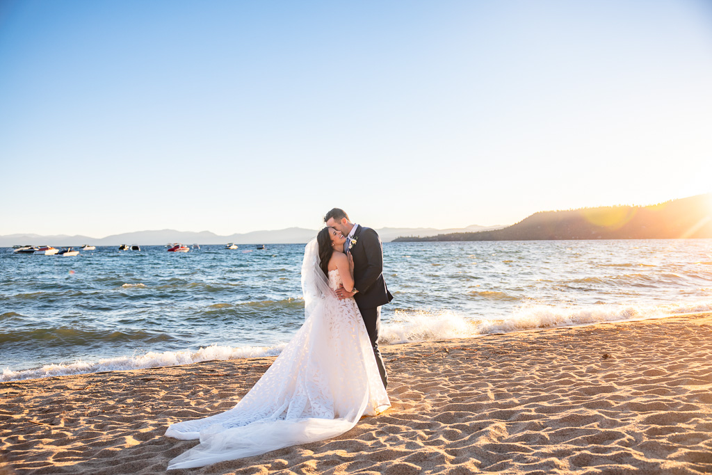 Bride and groom pose beside Lake Tahoe at sunset