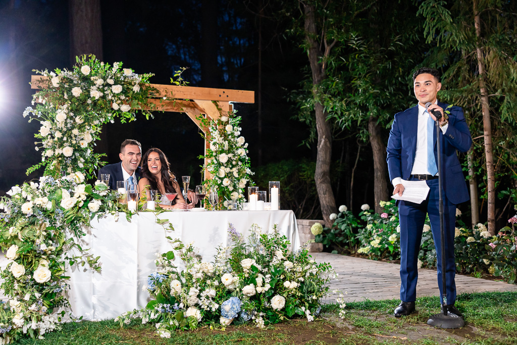 groomsman gives a toast beside the newlyweds at Hyatt Regency Lake Tahoe Resort while bride and groom laugh