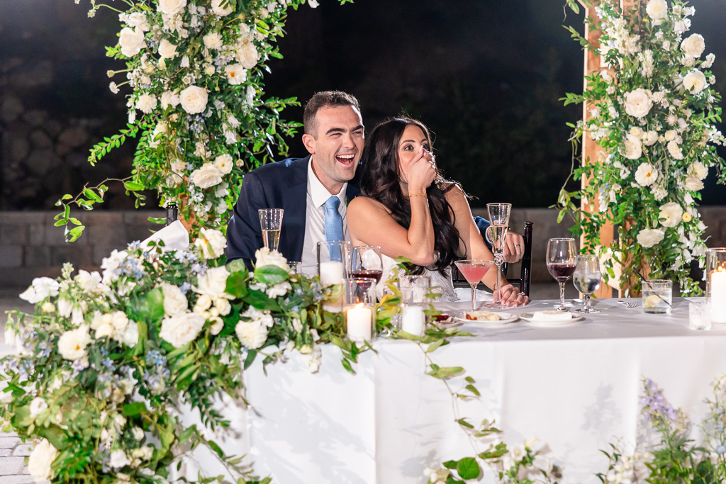 Bride and groom share a joyful and surprised moment during dinner toasts
