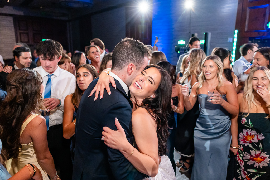Groom embraces the bride on the reception dance floor