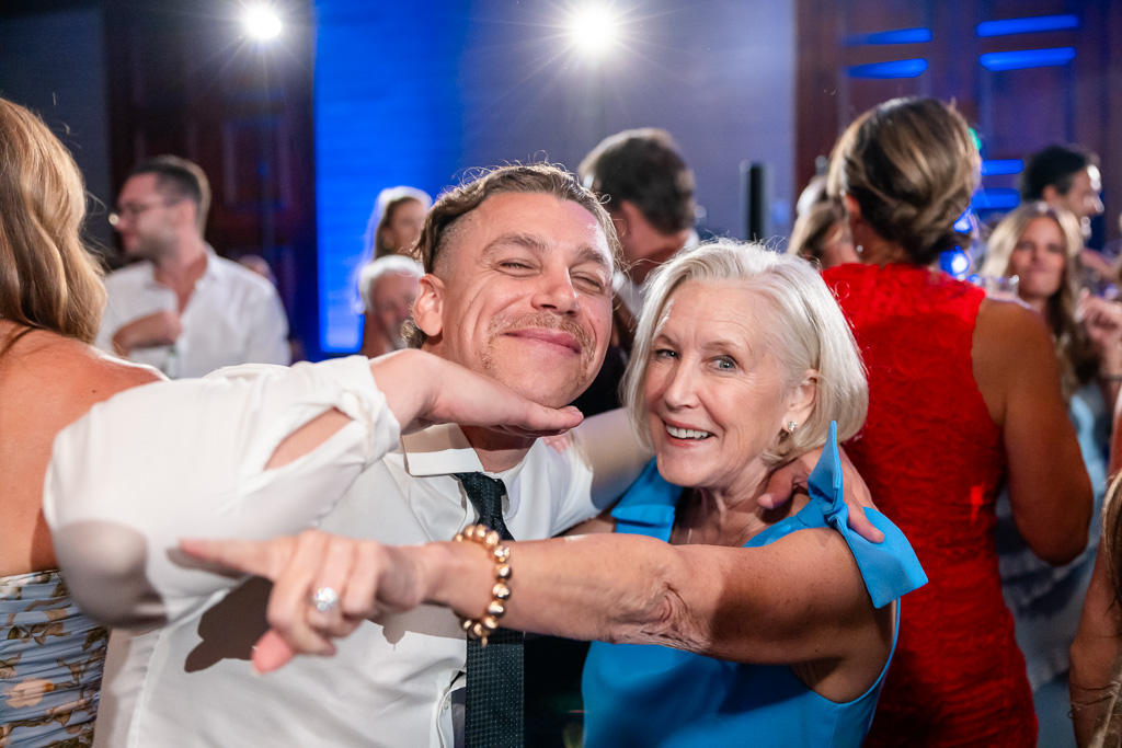 Wedding guest embraces an older woman on the dance floor