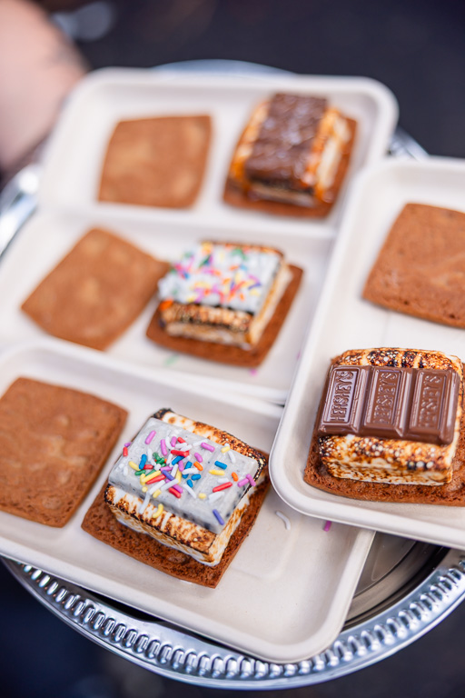Chocolate and marshmallow s’mores on graham crackers arranged on a serving platter.