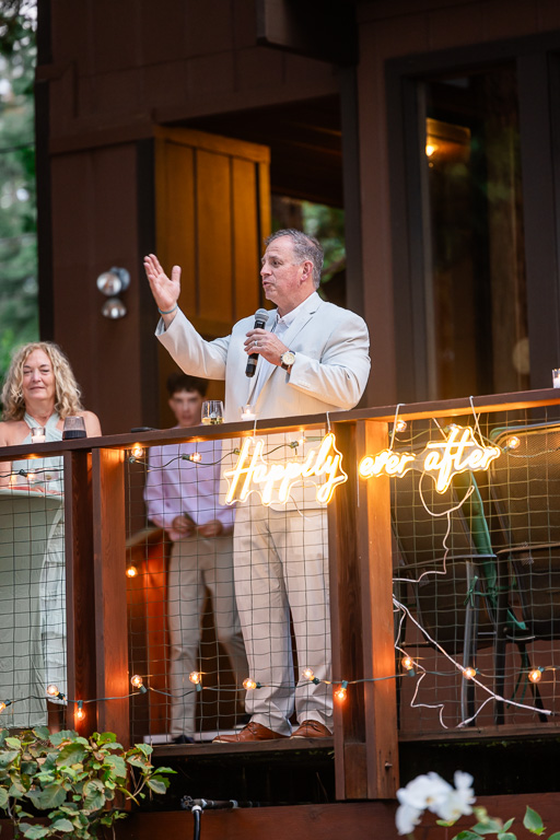 Father of the groom giving a speech from the backyard deck