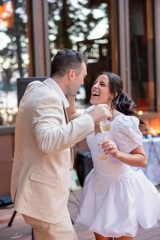 The couple laughs together over drinks during the lakeside gathering.