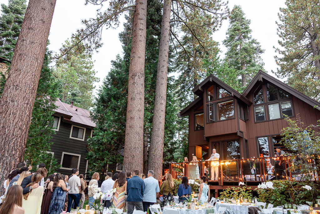 Guests gather beside the family’s lakefront home for an outdoor celebration before the wedding.