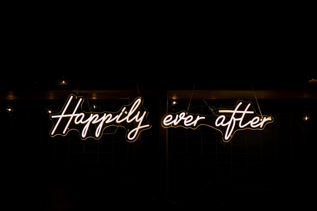 Neon “Happily Ever After” sign glowing on the deck during the couple’s pre-wedding celebration.