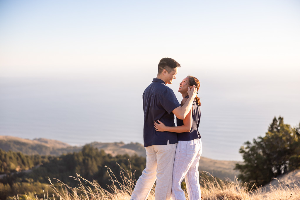 A couple holds each other close above the rolling hills as evening light falls over Mount Tamalpais.